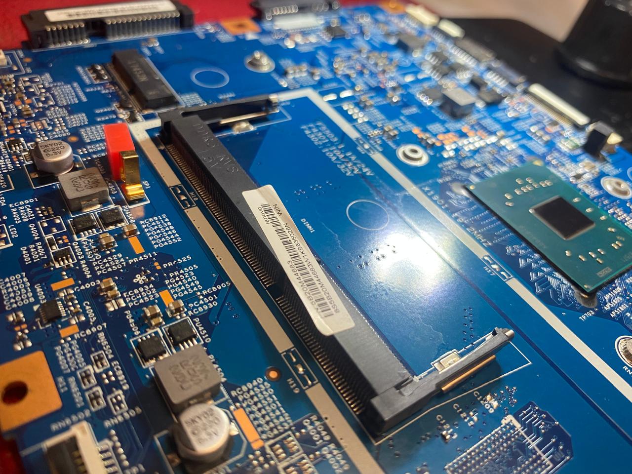 Placa madre de notebook con conector y componentes electrónicos en primer plano